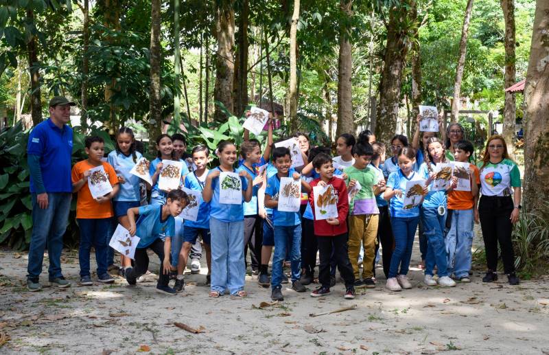 Alunos realizando atividades de colagem e pinturas com temática ambiental.