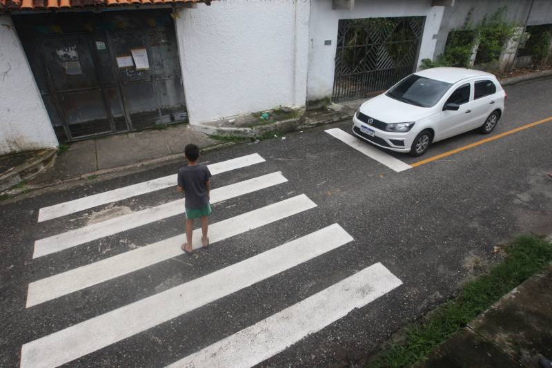 Criança atravessando na faixa de pedestres.