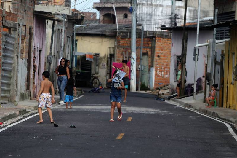 Crianças brincam com novo asfalto.