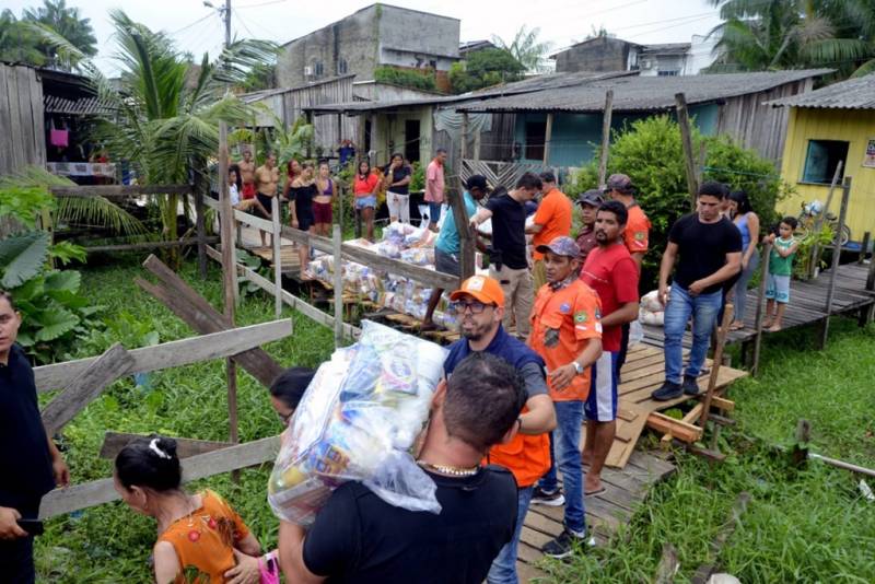 Prefeito Doutor Hugo Atayde entregando cestas básicas em comunidades atingidas pelas enchentes. 